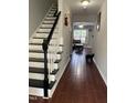 Hallway with wood floors and painted black-and-white stairs at 158 Randolph Dr, Clayton, NC 27520