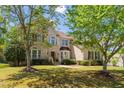 Beautifully landscaped two-story brick home with mature trees and a well-maintained lawn at 1602 Eagle Lodge Ln, Durham, NC 27703