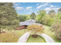 Aerial view showcasing the brick home, circular driveway, and lush surrounding landscape at 1750 Spring Valley Lake Rd, Henderson, NC 27537