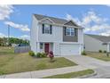 Well-kept two story home featuring a two-car garage, lawn and manicured landscape at 2065 Alderman Way, Creedmoor, NC 27522