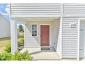 Close up of front door showing the door number, small window, and surrounding landscape at 2065 Alderman Way, Creedmoor, NC 27522