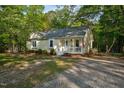 Well-kept home boasts a classic front porch, complemented by the natural beauty of its wooded surroundings at 2108 Canterbury Rd, Clayton, NC 27520