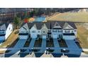 Overhead view of townhomes by a serene pond and athletic field, showcasing the community's layout at 2137 Caen St, Raleigh, NC 27610