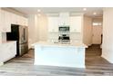 Bright, open kitchen with white cabinets, stainless steel appliances, and a large center island at 2137 Caen St, Raleigh, NC 27610