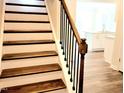Elegant staircase with wood treads and a dark iron railing, leading to the upper level at 2137 Caen St, Raleigh, NC 27610