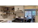 Open kitchen with wood shelving and stainless steel appliances overlooks the living area at 220 Elizabeth St # A-17, Chapel Hill, NC 27514