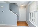 Bright entryway featuring hardwood floors, stairs leading up, and a large window at 228 Adefield Ln, Holly Springs, NC 27540