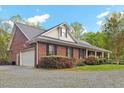 Brick home featuring an attached garage, lush landscaping, and inviting front porch at 2456 Nealwood Ave, Graham, NC 27253