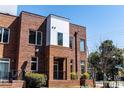 Modern brick exterior with contemporary design elements, lush landscaping, and outdoor seating at 256 William Drummond Way, Raleigh, NC 27604
