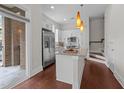 Modern kitchen featuring white cabinets, stainless steel appliances, and a granite-topped island at 256 William Drummond Way, Raleigh, NC 27604