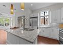 Bright kitchen with white cabinets, stainless steel appliances, and a large center island at 256 William Drummond Way, Raleigh, NC 27604
