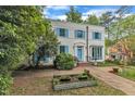 Charming two-story home with a white brick facade, blue shutters, and a well-manicured front yard at 2625 Dover Rd, Raleigh, NC 27608