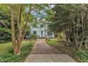 Charming two-story home with a white brick facade, blue shutters, and a brick walkway at 2625 Dover Rd, Raleigh, NC 27608