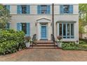 Close-up of white brick home highlighting blue door, shutters, and brick walkway at 2625 Dover Rd, Raleigh, NC 27608