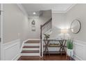Foyer with hardwood floors, staircase with white risers, and decorative console table at 2812 Lemnos Dr, Apex, NC 27502