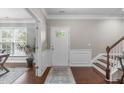 Inviting foyer with hardwood floors, elegant wainscoting, and a bright entrance with a glass paneled door at 2812 Lemnos Dr, Apex, NC 27502