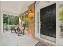 Cozy front porch with black rocking chairs, a view of the landscaped yard, and natural light at 314 Hogan Woods Cir, Chapel Hill, NC 27516