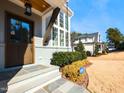 Inviting front entrance with stone steps, wood door, and meticulous landscaping at 3416 Edgemont Dr, Raleigh, NC 27612