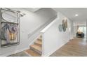 Well-lit entryway featuring neutral walls, modern decor, and a staircase with carpeted steps and white railings at 487 Lochalsh Dr, Gibsonville, NC 27249
