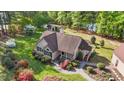 Aerial view of home featuring mature landscaping, inviting porch, detached garage and access to the lake at 50 Gill Ln, Fuquay Varina, NC 27526