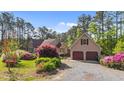 Beautiful home with a detached two-car garage, vibrant landscaping, and a private setting among mature trees at 50 Gill Ln, Fuquay Varina, NC 27526