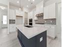 Bright, modern kitchen with white cabinets, stainless steel appliances, and a dark blue center island at 512 Gainer Dr # 4, Raleigh, NC 27610