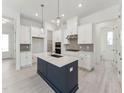 Bright, modern kitchen with white cabinets, stainless steel appliances, and a dark blue center island at 512 Gainer Dr # 4, Raleigh, NC 27610