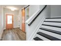 Bright foyer featuring a staircase, wood-look flooring, and a stylish peach-colored door at 528 Folk Song Way, Wendell, NC 27591