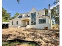 Gorgeous new construction home boasts a white brick, chimney, black framed windows, and green trees at 5504 Kingwood Dr, Raleigh, NC 27609