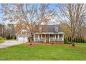 Charming home featuring a covered front porch, gray siding and dormer windows at 555 Canterwood Dr, Mebane, NC 27302