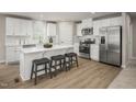 Modern kitchen with white cabinets, stainless steel appliances, a kitchen island, and wood flooring at 56 Saintsbury Dr, Fuquay Varina, NC 27526