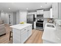 Spacious kitchen featuring stainless steel appliances, white cabinets, and a central island at 57 South Breeze Way, Fuquay Varina, NC 27526