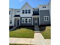 New construction townhome featuring a well-maintained lawn, a symmetrical facade, and contemporary design at 605 Callan View Ave, Wake Forest, NC 27587