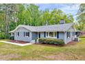 This home features gray brick, a flagpole, manicured shrubs, and a walkway to the front entrance at 612 E Academy St, Fuquay Varina, NC 27526