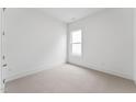Cozy bedroom showcasing neutral carpet, a large window, and white trim at 616 Gainer Dr # 15, Raleigh, NC 27610
