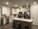 Bright kitchen boasts white cabinets, quartz countertops, stainless steel appliances, and a center island at 6332 Andante Ave, Raleigh, NC 27616