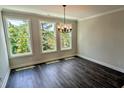 Bright dining room with large windows, chandelier, and wood floors; great natural light and a view at 687 Bandon Aly, Cary, NC 27513