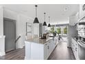 Spacious kitchen featuring a large island with bar seating, stainless steel appliances, and sleek pendant lighting at 687 Bandon Aly, Cary, NC 27513