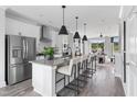 Bright kitchen boasts stainless steel appliances, a large center island with bar seating, and modern white cabinetry at 687 Bandon Aly, Cary, NC 27513