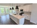 Modern kitchen features an island, stainless steel appliances and a dining area with lots of natural light at 687 Bandon Aly, Cary, NC 27513