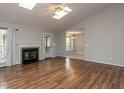 Spacious living room featuring a fireplace, hardwood floors, and natural light from skylights at 706 Mossburn Ct, Fuquay Varina, NC 27526