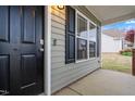Close-up of front door with secure lock, exterior siding, and view of the neighborhood at 72 E Moss Creek Dr, Clayton, NC 27520