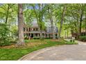 Beautiful brick home with mature trees, manicured lawn, and covered front porch at 7709 Oakmont Pl, Raleigh, NC 27615