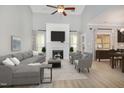 Bright living room with vaulted ceiling, fireplace and mantel, ceiling fan, and multiple windows at 8021 Crookneck Dr, Angier, NC 27501