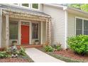 Inviting entrance with brick pathway, vibrant red door and lion statues at 919 Woodham, Pittsboro, NC 27312