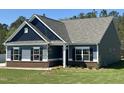 Inviting blue home showcasing classic architecture and a freshly planted tree at 95 Knoll Way, Sanford, NC 27332