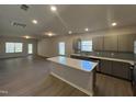 Modern kitchen with an island, stainless steel appliances, gray cabinets, subway tile backsplash, and ample natural light at 95 Knoll Way, Sanford, NC 27332