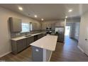 Well-equipped kitchen with quartz countertops, stainless steel appliances, gray cabinets, and an island with sink at 95 Knoll Way, Sanford, NC 27332