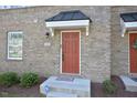 Close-up of the brick front of townhome with a welcoming, red front door at 1020 Kentlands Dr, Durham, NC 27713