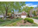 Charming brick home featuring a welcoming front porch, attached garage, and lush landscaping at 103 Temple Gate Dr, Cary, NC 27518